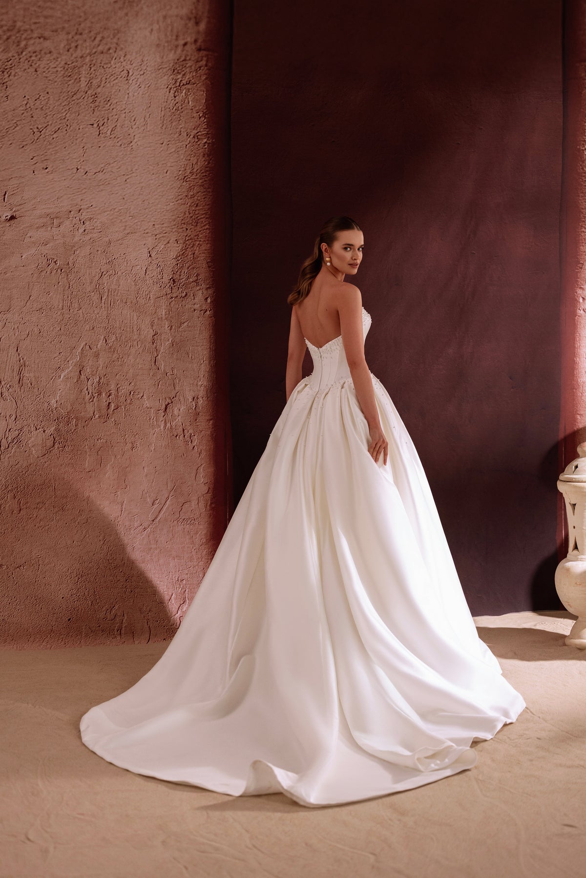 L’abito da sposa Noor, con scollo a cuore e corpetto aderente, valorizza la grazia femminile con eleganza raffinata.