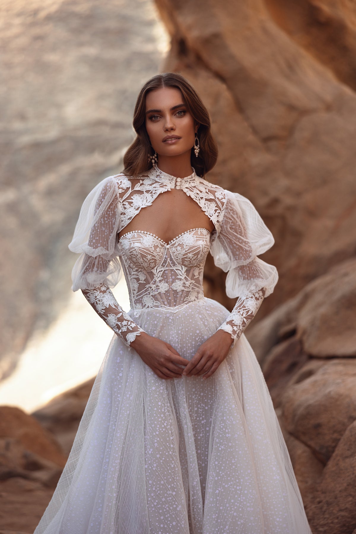 L’abito da sposa Oasis in pizzo, con maniche a sbuffo e gonna in tulle trasparente, unisce romanticismo vintage ed eleganza d’ispirazione couture.