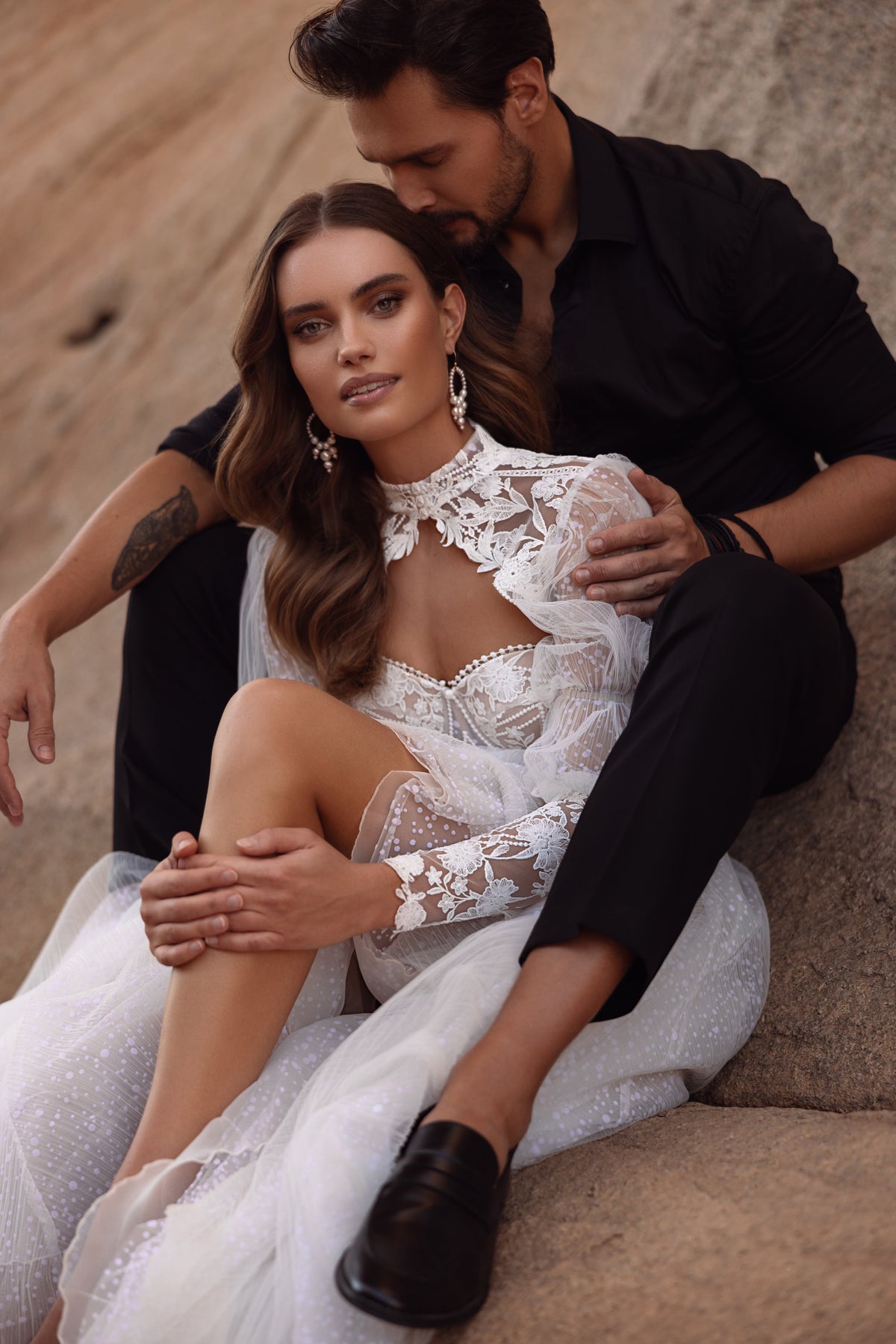 L’abito da sposa Oasis, con strascico fluido e dettagli in pizzo, esprime bellezza eterea e grazia femminile.