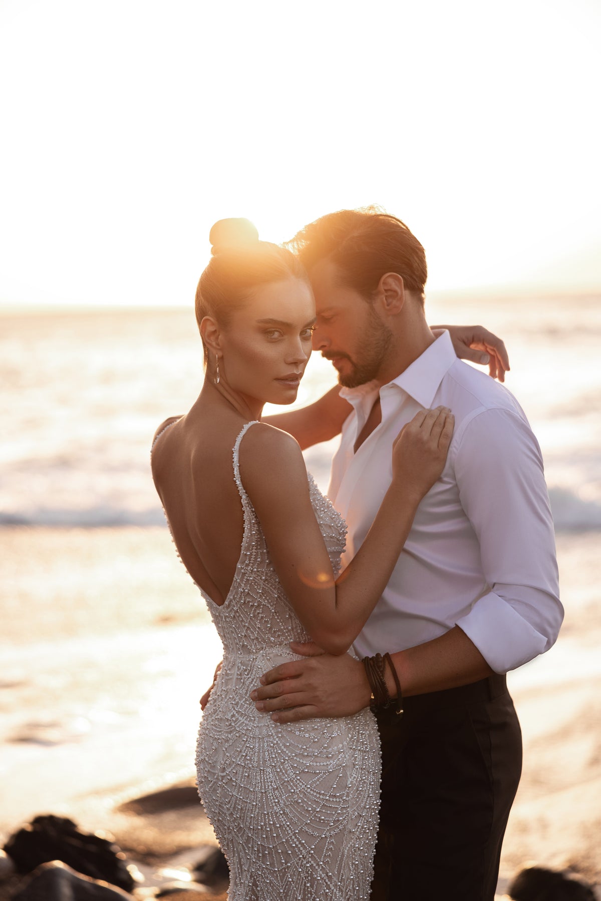 L’abito da sposa Rebecca, con profondo scollo a V e linea aderente, esprime eleganza contemporanea e raffinatezza senza tempo.