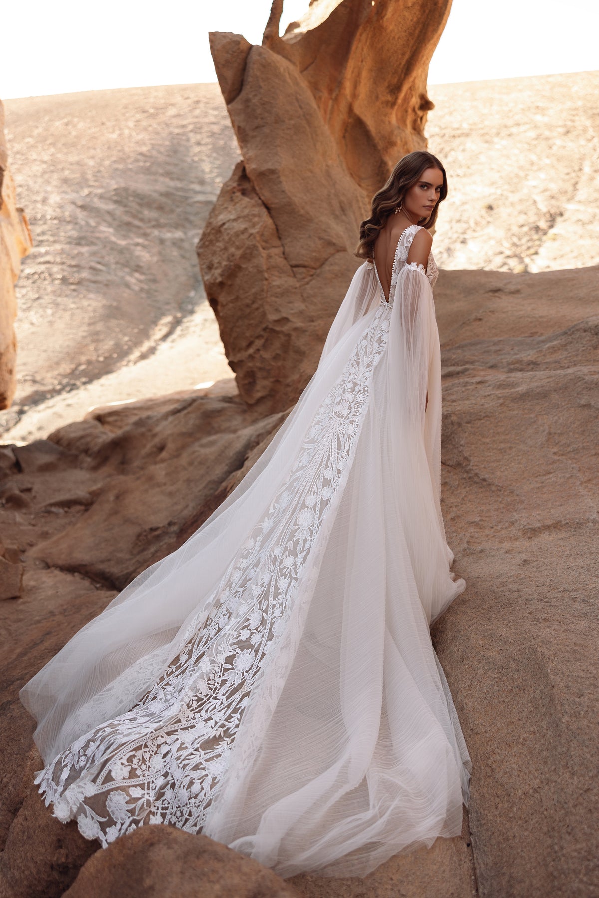 L’abito da sposa Salome, con strascico cattedrale e ricchi ricami in pizzo, esprime un lusso bohémien.