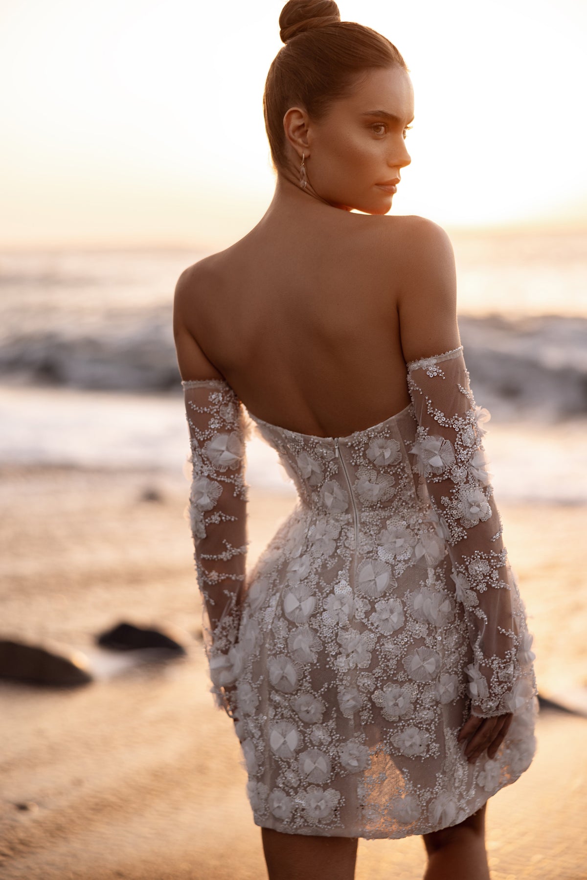 L’abito da sposa Kayla, con scollo a cuore e ricami in pizzo, valorizza le curve nella luce del tramonto.