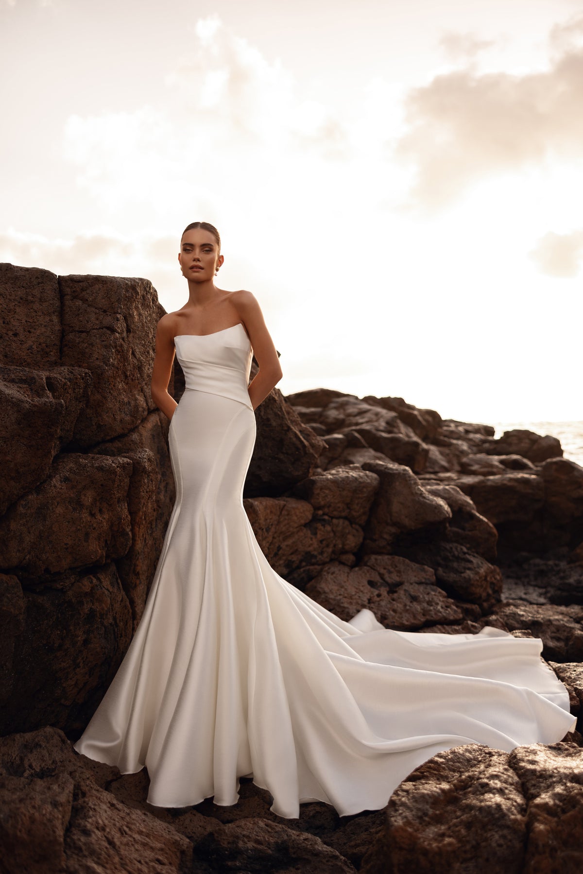 L’abito da sposa Soraya a sirena, con schiena scoperta, valorizza la figura nella luce dorata del tramonto.