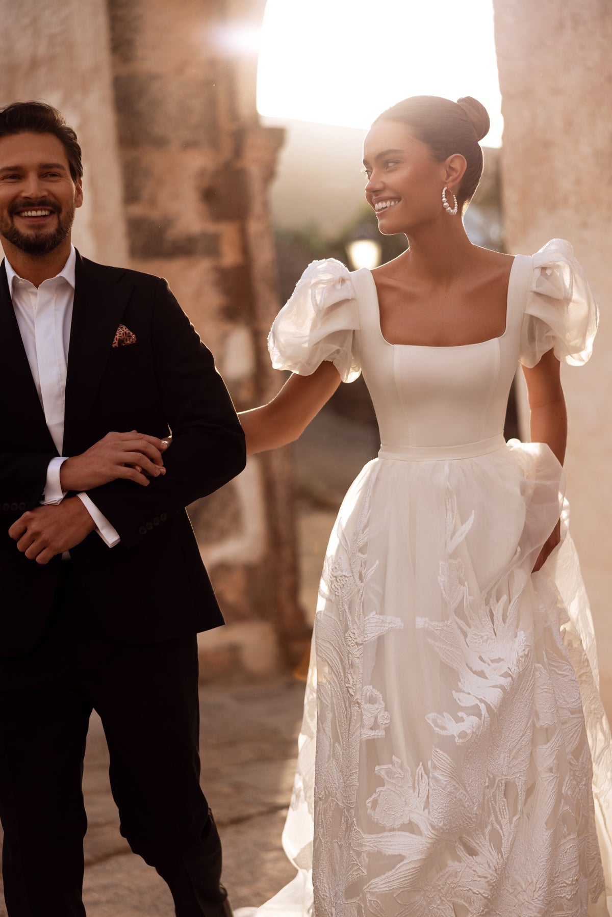 L’abito da sposa Vanilla, con maniche a sbuffo in organza e dettagli ricamati, crea un look sognante.