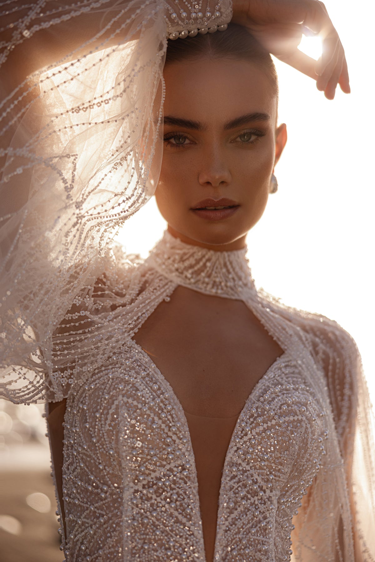 Bolero Venus – collo alto decorato di perline, apertura a goccia e manica trasparente con perline, primo piano.