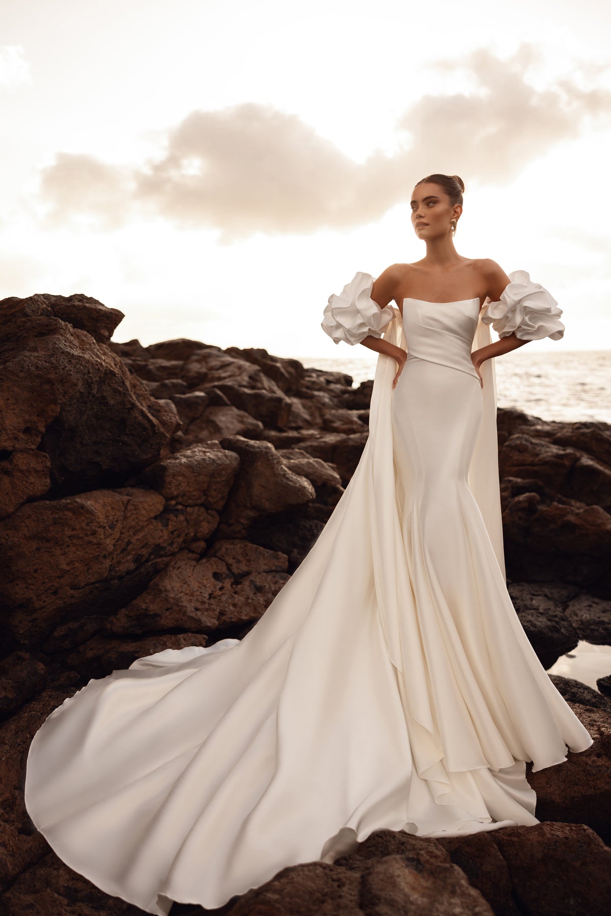 Abito da sposa contemporaneo con maniche a sbuffo e lungo strascico scenografico, per un look prezioso.